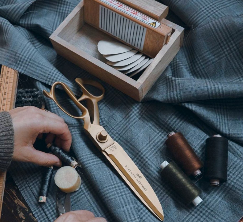 Tailor's scissors, thread and checked cloth at Stallion Bespoke, Dubai
