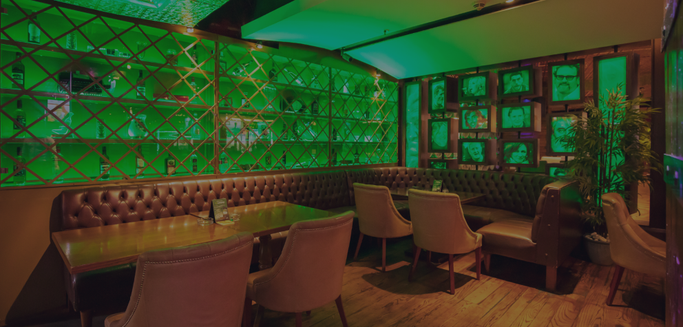 Booth seating and green-lit wall display at McGettigan's JLT, Dubai