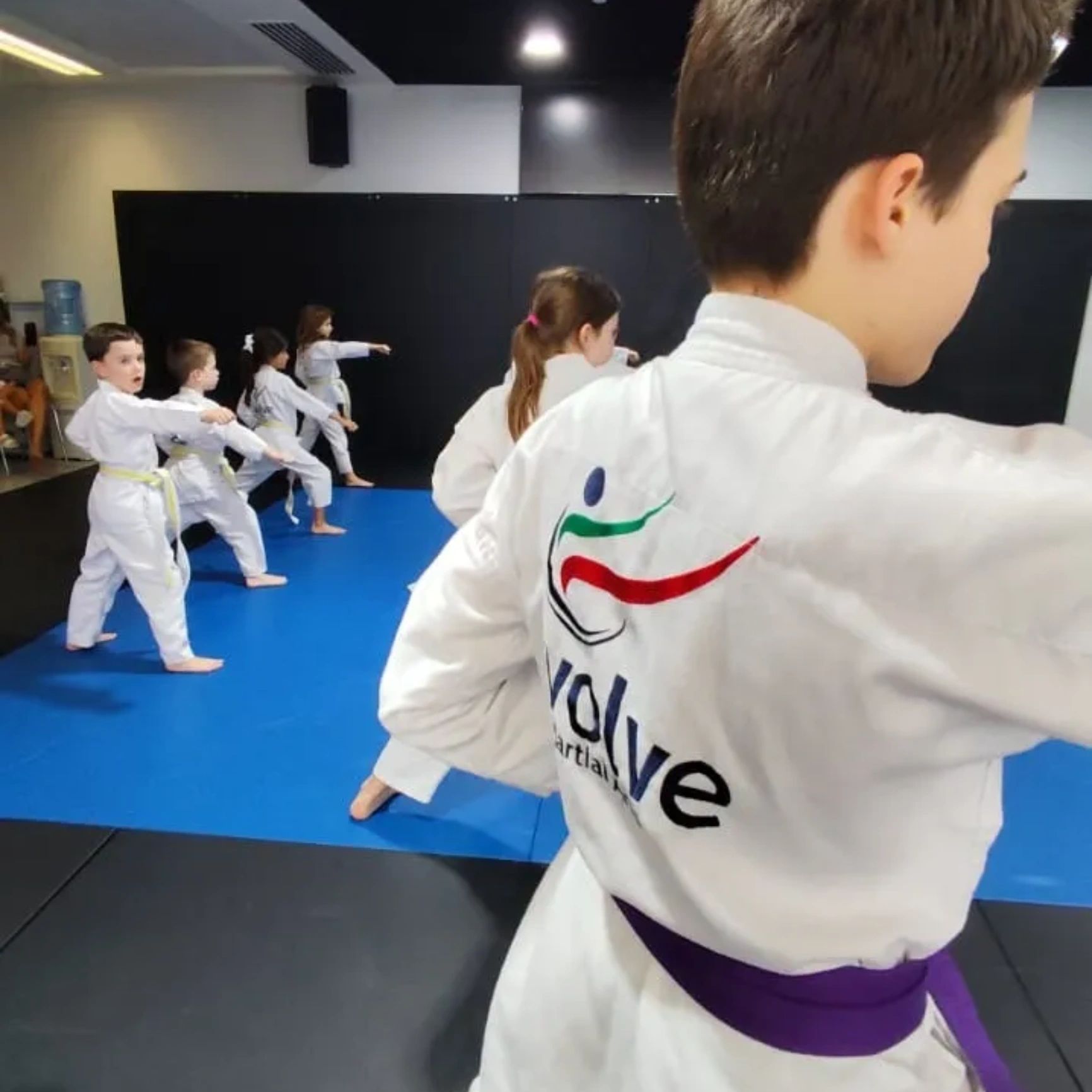 Young students training in Evolve martial arts uniforms at Evolve Academy, Motor City