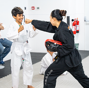Instructor and child training in the dojo at The Warrior Academy Al Quoz